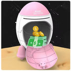 Pink and white space-themed money box with coins and money bills inside, on a wooden surface.