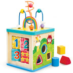 A colorful wooden children's activity box with shape and number sorting slots, rainbow bead wires, and small toy blocks placed beside it on a white background.