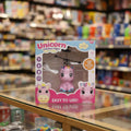 A boxed toy helicopter labeled 'Unicorn induction flight' displayed on a glass retail counter with a blurred toy store interior in the background.