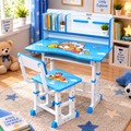 A children's adjustable desk and matching chair set in a bright, decorated room. The desk and chair are primarily white with bright blue accents, featuring cartoon dog graphics on the desktop and seat.