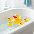 Five yellow rubber ducks in a bathtub with water.