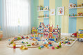 Children's playroom with colorful toys and a toy train set on a wooden floor.