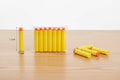 Yellow foam darts with measurement on a wooden surface