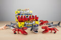 Toy figures of dinosaurs and sharks with packaging on a wooden surface