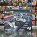 A boxed remote control racing  car labeled 'CZOU Aircraft' and '2.4GHZ' sits on a reflective surface with a blurred toy store background.