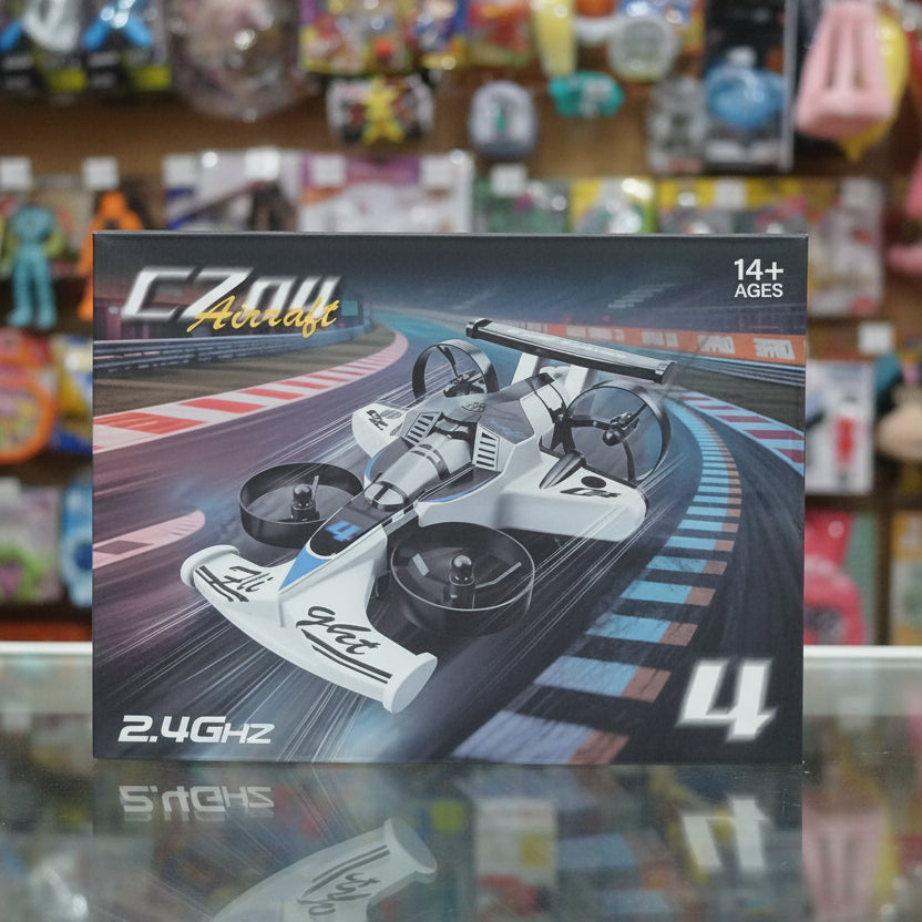 A boxed remote control racing  car labeled 'CZOU Aircraft' and '2.4GHZ' sits on a reflective surface with a blurred toy store background.