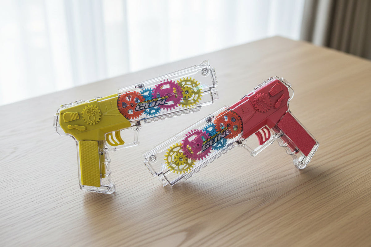 Two transparent toy guns with colorful designs on a wooden surface.
