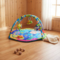 Colorful baby play mat with toys on a wooden floor