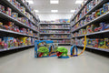 Toy aisle with shelves stocked with various toys, featuring a toy snake on the floor.