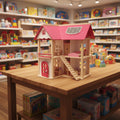 Toy house on a wooden table with a toy store in the background
