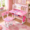 Pink children's desk and chair set with cartoon character prints, shown in a decorated pink room with books, shelves, and heart-patterned decor.
