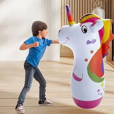 Child playing with a colorful inflatable unicorn toy indoors.
