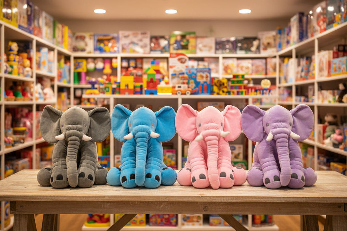 Four colorful elephant plush toys on a table with toy shelves in the background